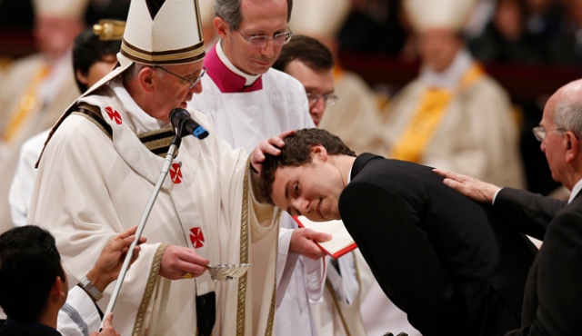 Pope Francis baptizes a young man during the Easter Vigil in St. Peter's Basilica at the Vatican March 30. (CNS photo/Paul Haring) (March 31, 2013) See FRANCIS-EASTER March 31, 2013.